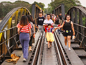 Little girl in Snow White costume walking over the Bridge on the River Kwai, a part of the Death Railway in Kanchanaburi, Thailand, photo by Ivan Kralj