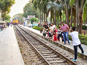 People posing for the photo by the train tracks of the Death Railway, the Second World War site where more than a hundred thousand people died, captured in Kanchanaburi, Thailand, photo by Ivan Kralj