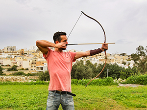 Pipeaway blogger Ivan Kralj holding a bow and an arrow at Falcon Archery Malta course, photo by Damir Vidakovic