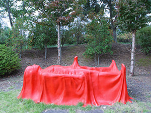 Red sculpture of a man under a cover with visible erection, Jeju Loveland sex museum, Jesu Island, South Korea, photo by Ivan Kralj