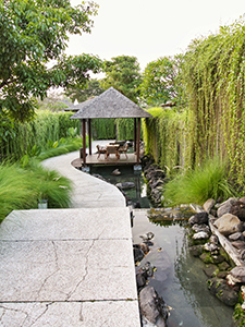 Vine-covered walls of the villas in The Santai Bali resort, pathway between them with artificial water stream and Balinese gazebo, Indonesia, photo by Ivan Kralj