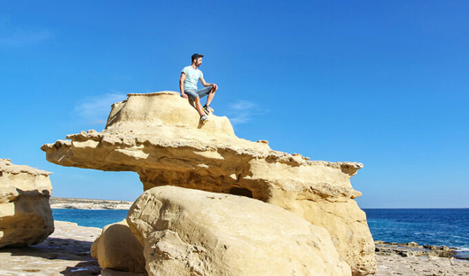 Pipeaway blogger Ivan Kralj sitting on the rock at St. Peter's Pools in Malta, photo by Damir Vidakovic
