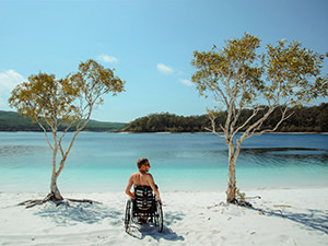 Slaven Škrobot, a traveler in a wheelchair, on a sandy beach on Fraser Island, Australia