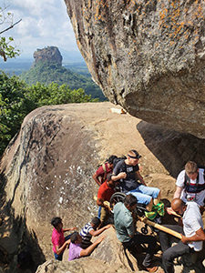 Assistants carrying Slaven Škrobot in an improvised wheelchair stretcher to the top of Pidurangala rock in Sri Lanka