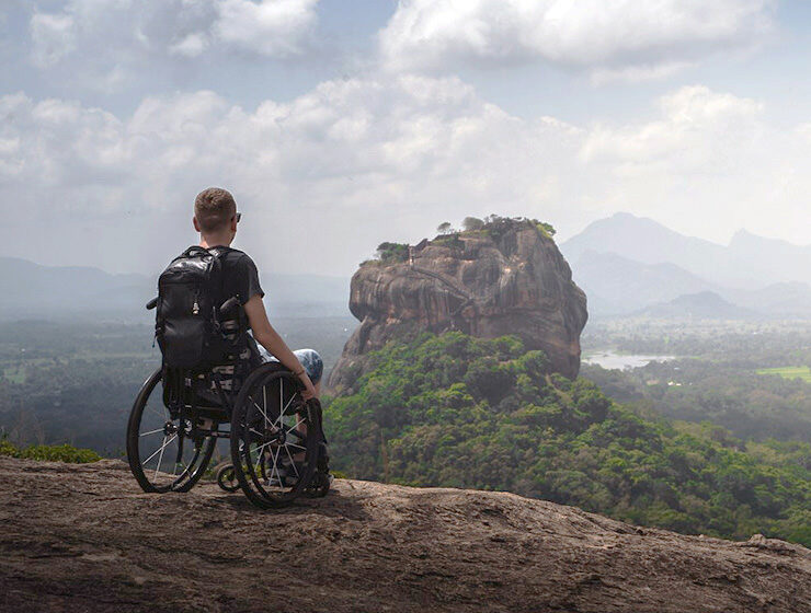 Slaven Škrobot, a traveler in a wheelchair, on the top of the Pidurangala rock with a view of Sigiriya rock in Sri Lanka