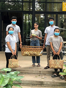 Treeline hotel workers holding food prepared to donate to those affected by coronavirus crisis in Cambodia