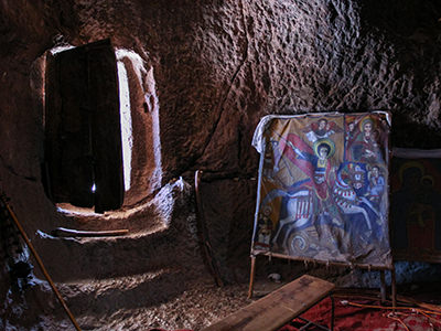 Entrance to a cave-like rock-hewn church Bet Denagel, with a painting of St. George killing a dragon. Lalibela. Ethiopia. Photo by Ivan Kralj