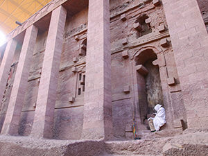 A pilgrim sitting outside of Bet Medhane, the largest Lalibela church carved out of rock, Ethiopia. Photo by Ivan Kralj