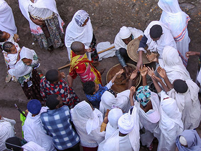 Pilgrims gathered around the bread-giver at Eucharist on Sunday mass in one of Lalibela churches, Ethiopia, photo by Ivan Kralj