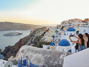 Cruise ship inside the caldera of Santorini, as seen from Oia Blue Domes, popular churches during sunset, Greece, photo by Ivan Kralj