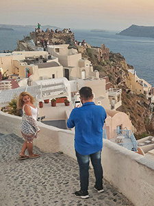 Woman posing while her partner is photographing her in front of the Byzantine castle in Oia during the famous Santorini sunset, photo by Ivan Kralj
