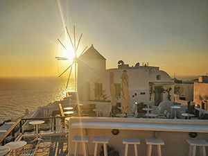 Oia windmill with an empty bar and sun setting behind it during the very unusual COVID-19 Santorini sunset, Greece, photo by Ivan Kralj