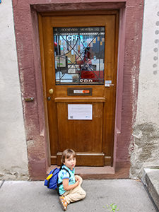 Grandson of Vergeat family sitting in front of the Hoosesagg Museum, displayed in the door of a private house, as the smallest museum in Basel, Switzerland, photo by Ivan Kralj