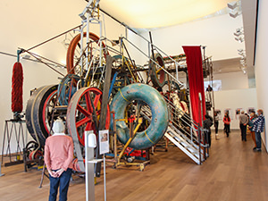 Woman looking at a gigantic kinetic art installation by Jean Tinguely, as displayed in Museum Tinguely, in Basel, Switzerland, photo by Ivan Kralj