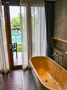 Bathtub in the bathroom of Sakmut Hotel & Spa overlooking a swimming pool, Siem Reap, Cambodia