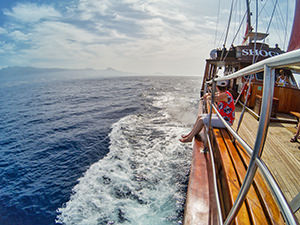 A woman sitting on the edge of the Shogun boat sailing by the Tenerife island, Spain, photo by Ivan Kralj