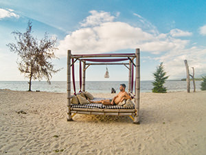 Travel blogger Ivan Kralj laying on a beach bed at Sire Beach, Lombok, Indonesia, photo by Mladen Koncar
