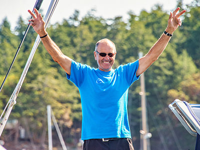 Bert terHart raising hands in the air on his return from successful circumnavigating the globe