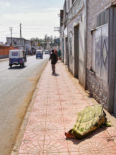 Blanket-covered man sleeping in the street of Harar carefree, even if this town is known for hyenas freely entering it in search for food, Ethiopia, photo by Ivan Kralj