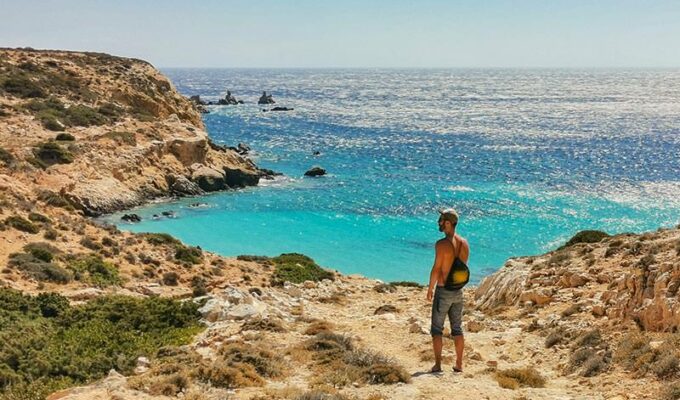 Pipeaway blogger Ivan Kralj standing at the coastline of Donousa, an island in Greece, one of the top 10 countries to discover in 2021 according to international travel predictions 2021, photo by Nikos Samartzis