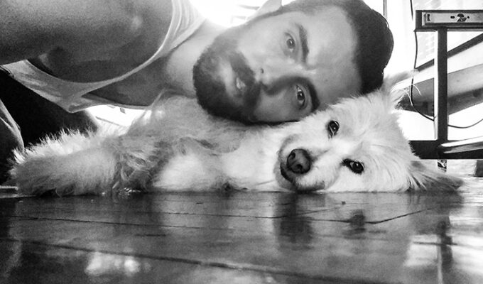 Dogsitting the rescued dog, Ivan Kralj taking care of a dog named Krumpira, lying together on the floor, black-and-white photo by Ivan Kralj