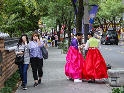 Young women covering their eyes after they have seen two young men crosdressing like ladies in the street of Jeonju, South Korea, photo by Ivan Kralj