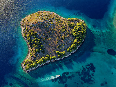 Heart-shaped island of Lukovnik in the Adriatic Sea, Croatia, in front of the village of Tribunj, aerial photo by Boris Kačan