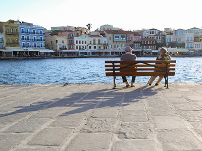 Elderly couple with a long shadow sitting on the bench in Chania, Crete, Greece, photo by Ivan Kralj