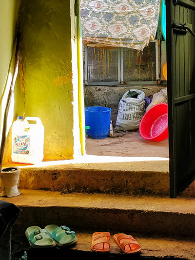 Door entrance to a Couchsurfing home in a slum of Bahir Dar, Ethiopia, with sandals, canisters and bowls lying around, photo by Ivan Kralj
