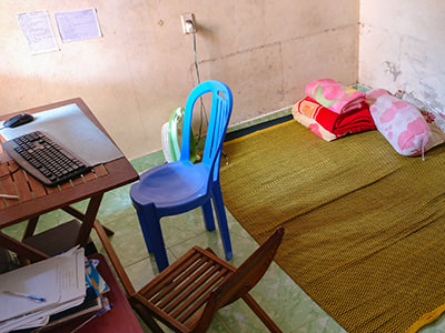 A couchsurfing room in Danang, Vietnam, with a couple of chairs, computer, fan, and a carpet on the floor instead of bed, photo by Ivan Kralj