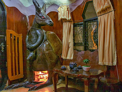 Kangaroo sculpture as a fireplace with a tea set on the table in the Australia-dedicated room at Crazy House / Hang Nga Guesthouse in Dalat, Vietnam, photo by Ivan Kralj