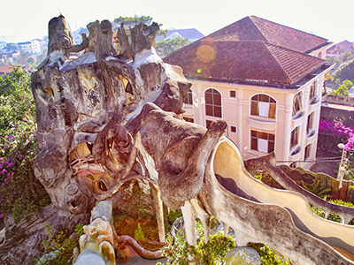 The building of Crazy House resembling a tree stump standing next to the French colonial villas of Dalat in Vietnam, photo by Ivan Kralj