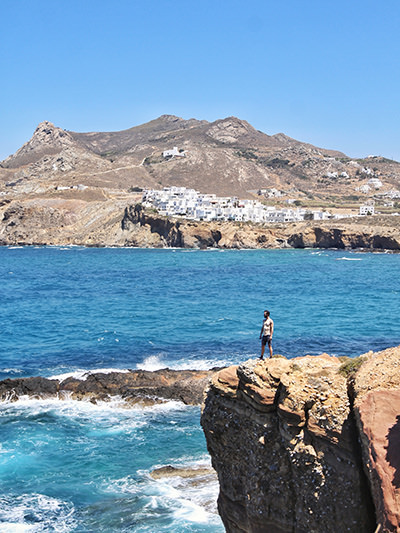 Digital nomad Ivan Kralj standing on the cliff above the wild sea in Naxos Island, Cyclades, Greece, photo by Mladen Koncar