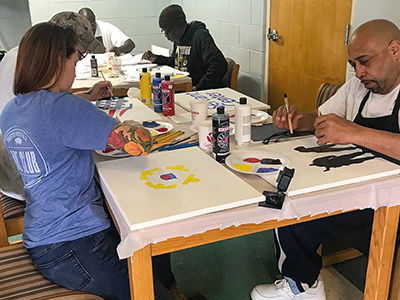 Jessica Rambo from Painted Buffalo Art Studio in an art workshop with American military veterans