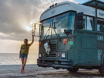 Jessica Rambo, American veteran standing next to her house on wheels, a school bus converted to Painted Buffalo traveling studio