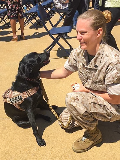 Marine Corps veteran Jessica Rambo petting her service dog Bella