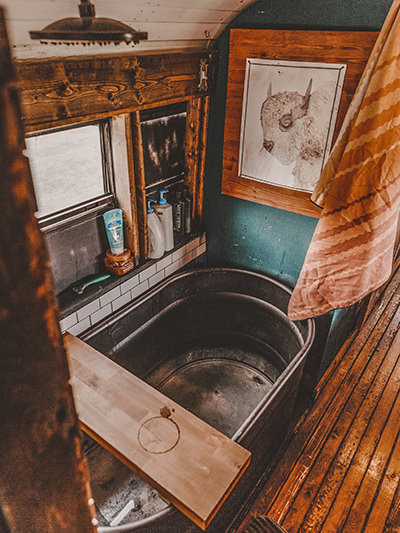 Bathtub inside Painted Buffalo Traveling Studio, a school bus converted into a house on wheels by Jessica Rambo