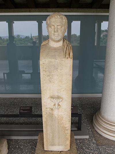 An unfinished portrait herm from the early 3rd century probably presenting a Kosmetes, including his head on the top of the pedestal, and genital area carved on the front side of the pedestal, exhibited in Stoa of Attalos, Athens, Greece, photo by Ivan Kralj