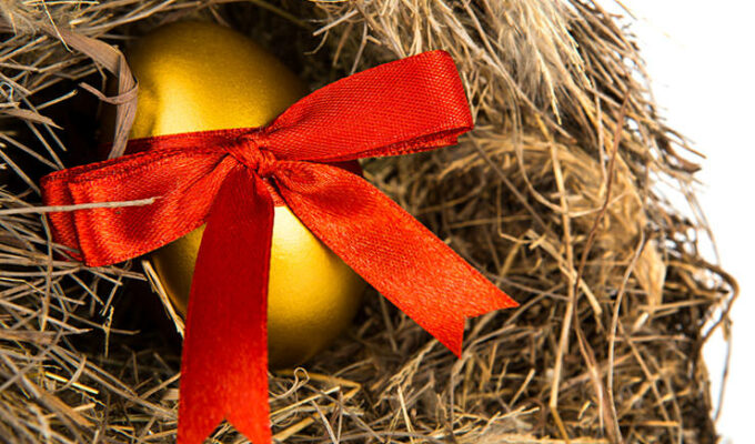Golden Easter egg with a red ribbon in a nest made of straw, created by jannoon029, freepik.com