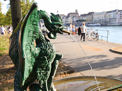 Water fountain with basilisk on Rhine promenade in Basel, Switzerland. Walking along the Rhine is one of the best free things to do in Basel, and drinking water is also complimentary. Photo by Ivan Kralj