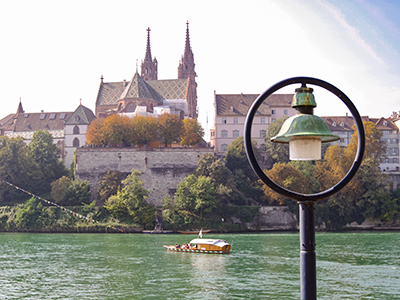 Ferry crossing the Rhine River in front of the Basel Münster church in Basel, Switzerland. These ferries use the natural power of river's current to bring passengers to the other side. Photo by Ivan Kralj