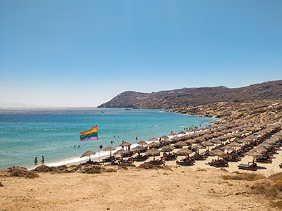 Elia gay beach in Mykonos, Cyclades, Greece, marked by rainbow flag and thatched parasols, photo by Ivan Kralj