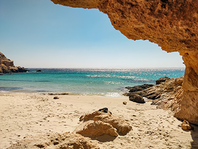 Shade under the arching rock at Fikio Beach in Donousa, one of the best nude beaches in Cyclades Islands, Greece, photo by Ivan Kralj
