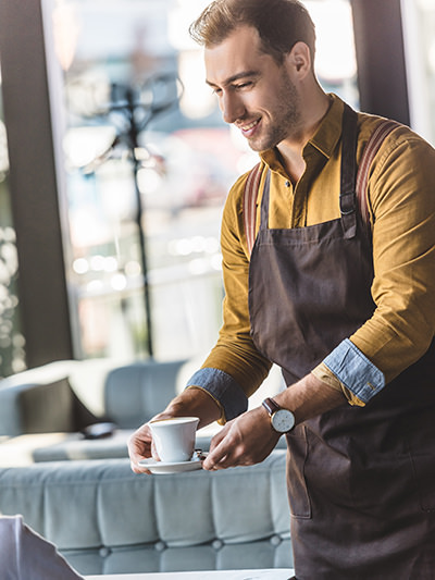 Waiting tables in a bar: barista serving a cup of coffee to a client, photo by AllaSerebrina, Depositphotos