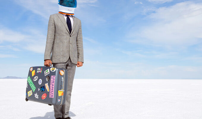 Space travel tourist businessman with suitcase in a desert prepared for traveling to the Moon, photo by Lazyllama / Depositphotos.com