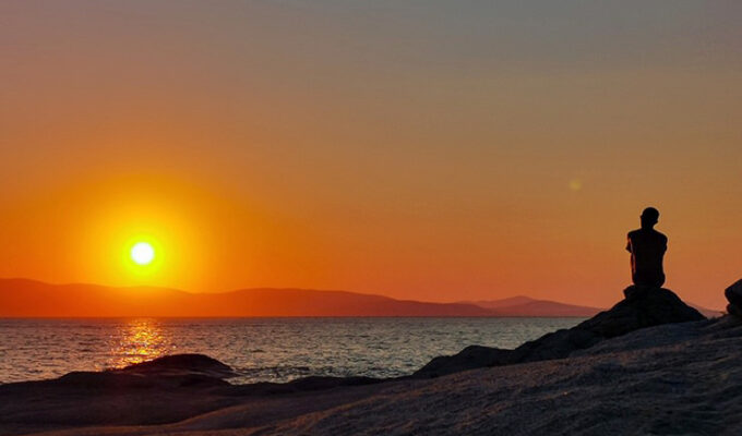 A silhouette of a man in front of the sunset on the beach in Naxos, Greece, photo by Nikos Samartzis