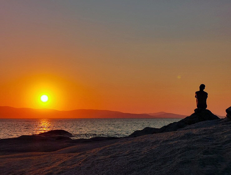 A silhouette of a man in front of the sunset on the beach in Naxos, Greece, photo by Nikos Samartzis
