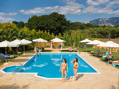 Naked women standing by the swimming pool at Vassaliki Naturist Club in Kefalonia, one of the best clothing-optional resorts in Greece, photo by Vassaliki