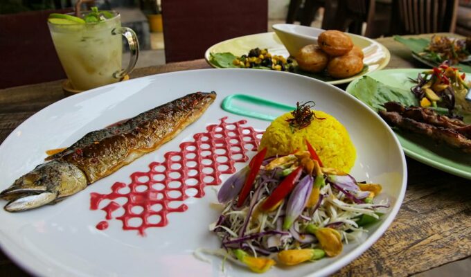 Colorful plate of a grilled mackerel with turmeric rice, beetroot sauce, and wasabi mayonnaise with butterfly pea flowers, served in Pou Restaurant and Bar, one of the best Siem Reap restaurants, Cambodia, photo by Ivan Kralj