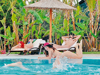 Naked ladies and gentleman resting by the swimming pool at Naturist Angel Club Hotel in Rhodes, one of the best clothing-optional resorts in Greece